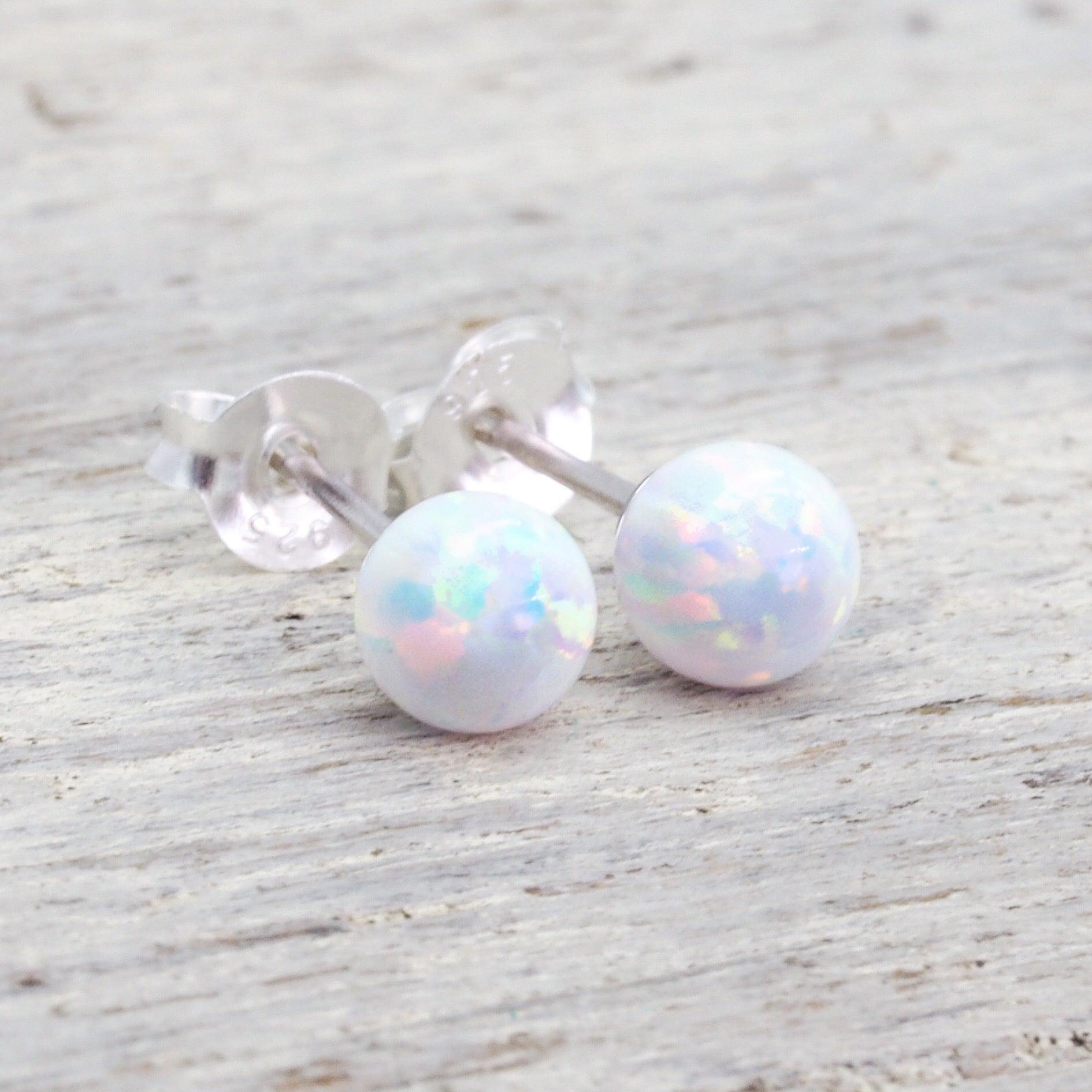 Dainty white opal ball stud earrings with iridescent pastel hues, set in polished sterling silver.