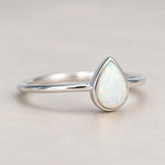 Angled view of the Dainty White Opal Teardrop Ring, showing its slim sterling silver band and smooth bezel setting.