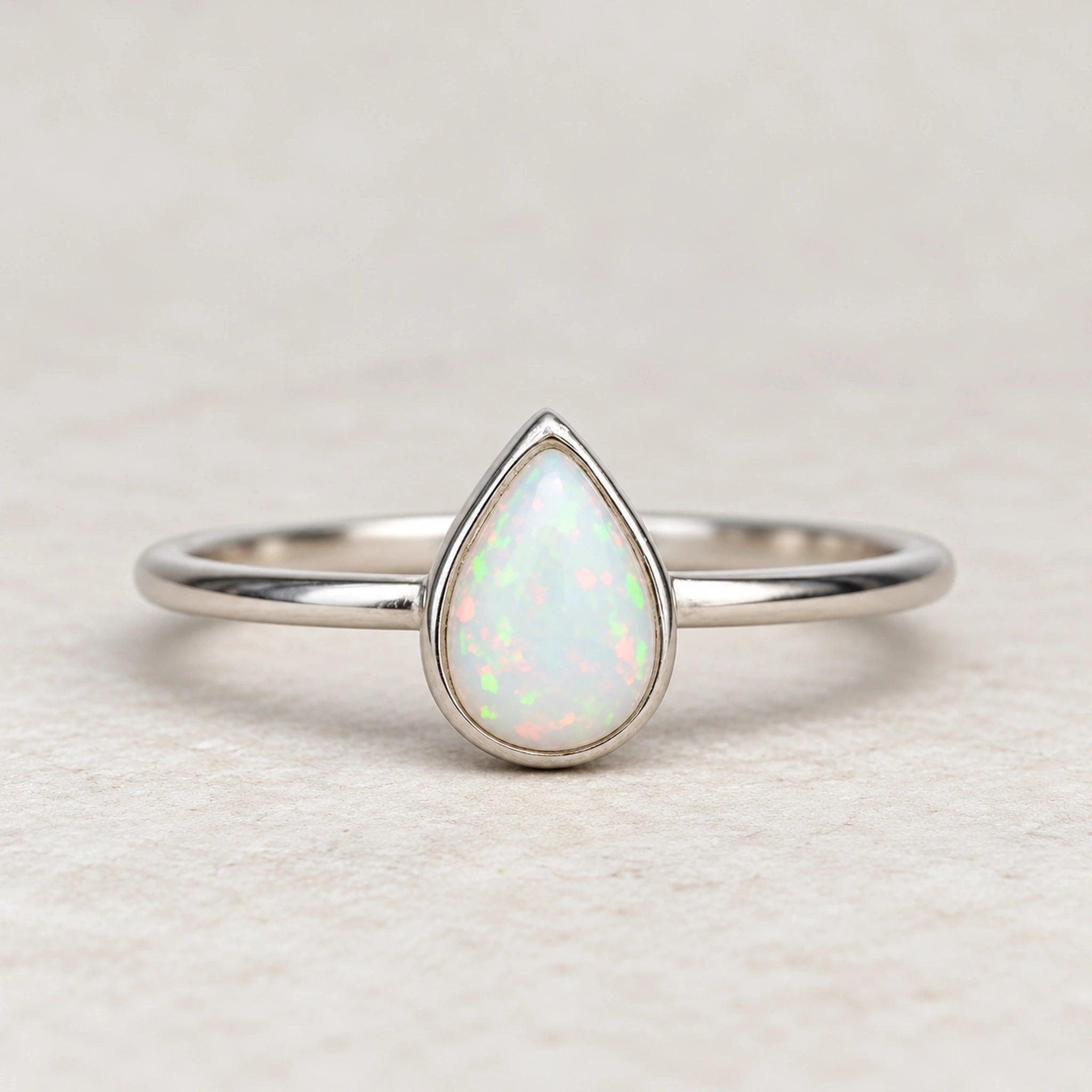 Dainty White Opal Teardrop Ring in polished sterling silver, front view showing the pear-shaped lab-grown opal.