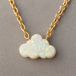 Opal cloud pendant on a gold chain against a gray background