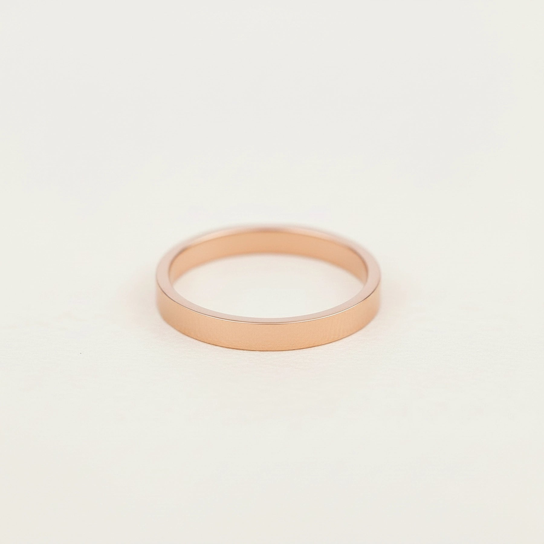 rose gold band stacker ring on a grey surface