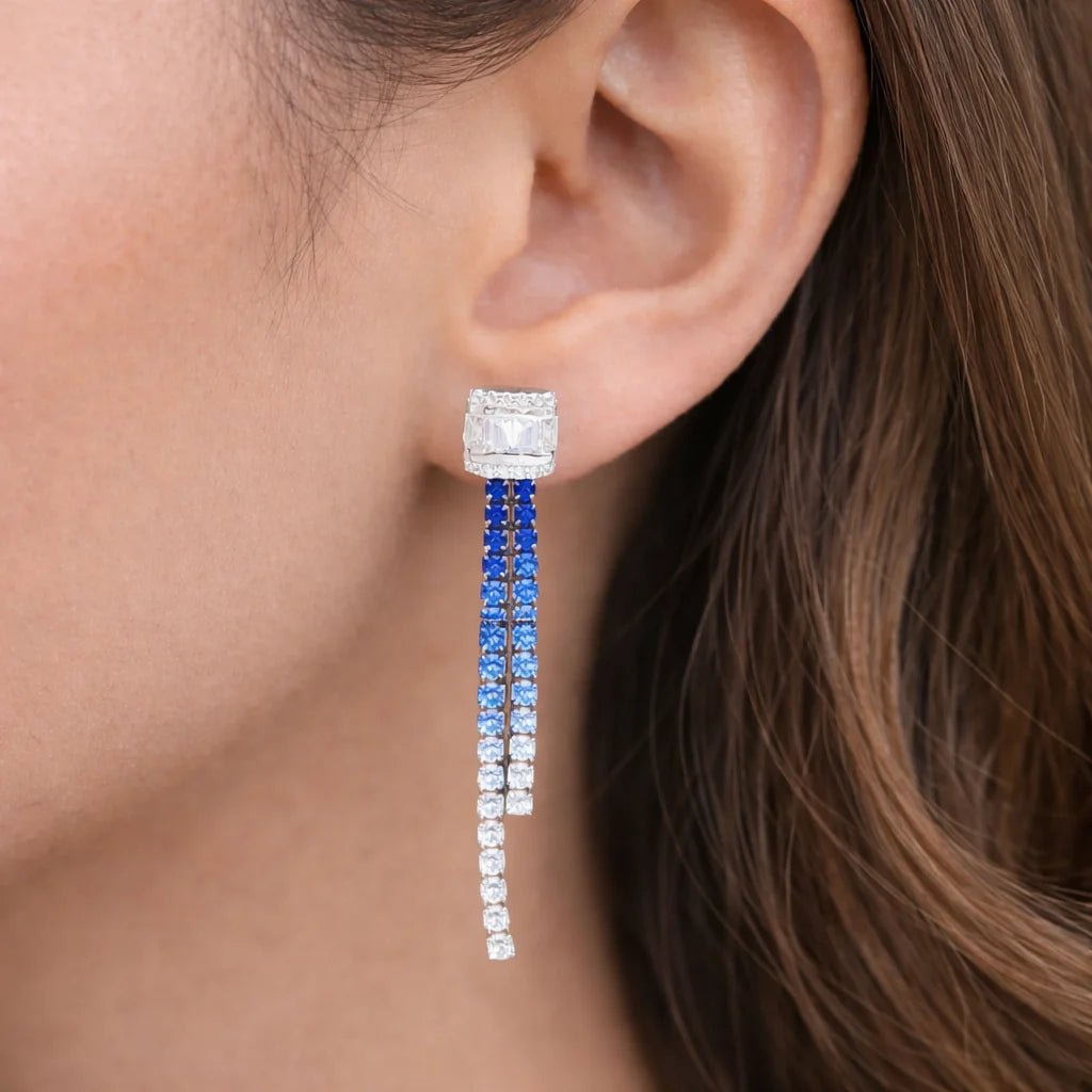 Close-up of an ear wearing a blue and white cz earring.