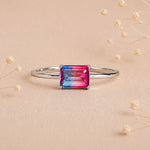Sterling Silver Ring with an emerald cut Cotton Candy Tourmaline Gemstone with blue and pink colours on a soft light surface.