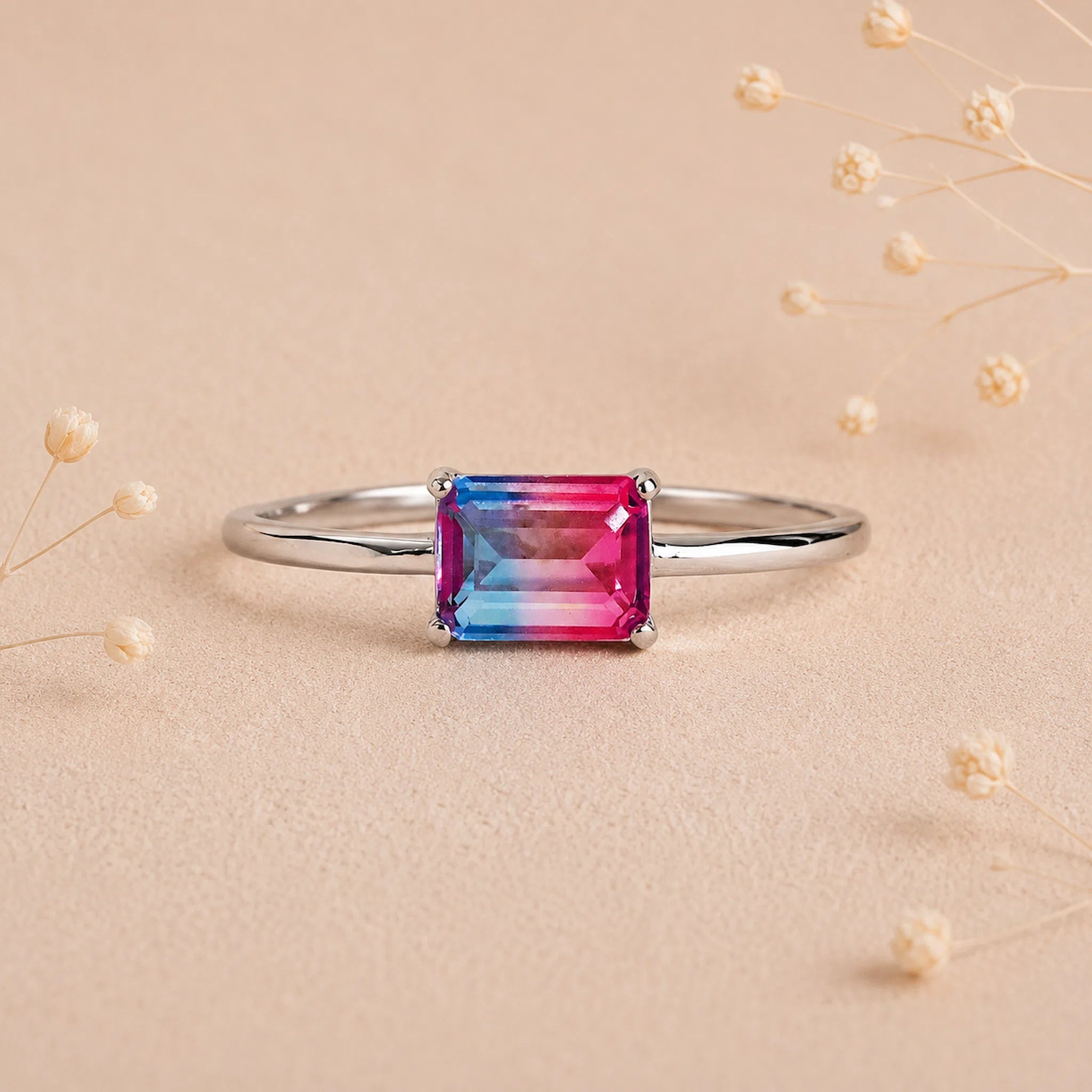 Sterling Silver Ring with an emerald cut Cotton Candy Tourmaline Gemstone with blue and pink colours on a soft light surface.