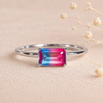 Sterling Silver Ring with an emerald cut Cotton Candy Tourmaline Gemstone with blue and pink colours on a soft light surface.