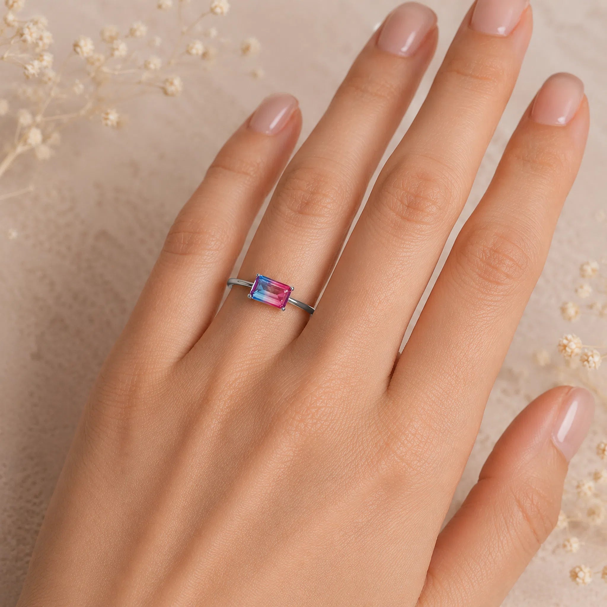 Sterling Silver Ring with an emerald cut Cotton Candy Tourmaline Gemstone with blue and pink colours being worn.