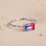 side view of Sterling Silver Ring with an emerald cut Cotton Candy Tourmaline Gemstone with blue and pink colours on a soft light surface.