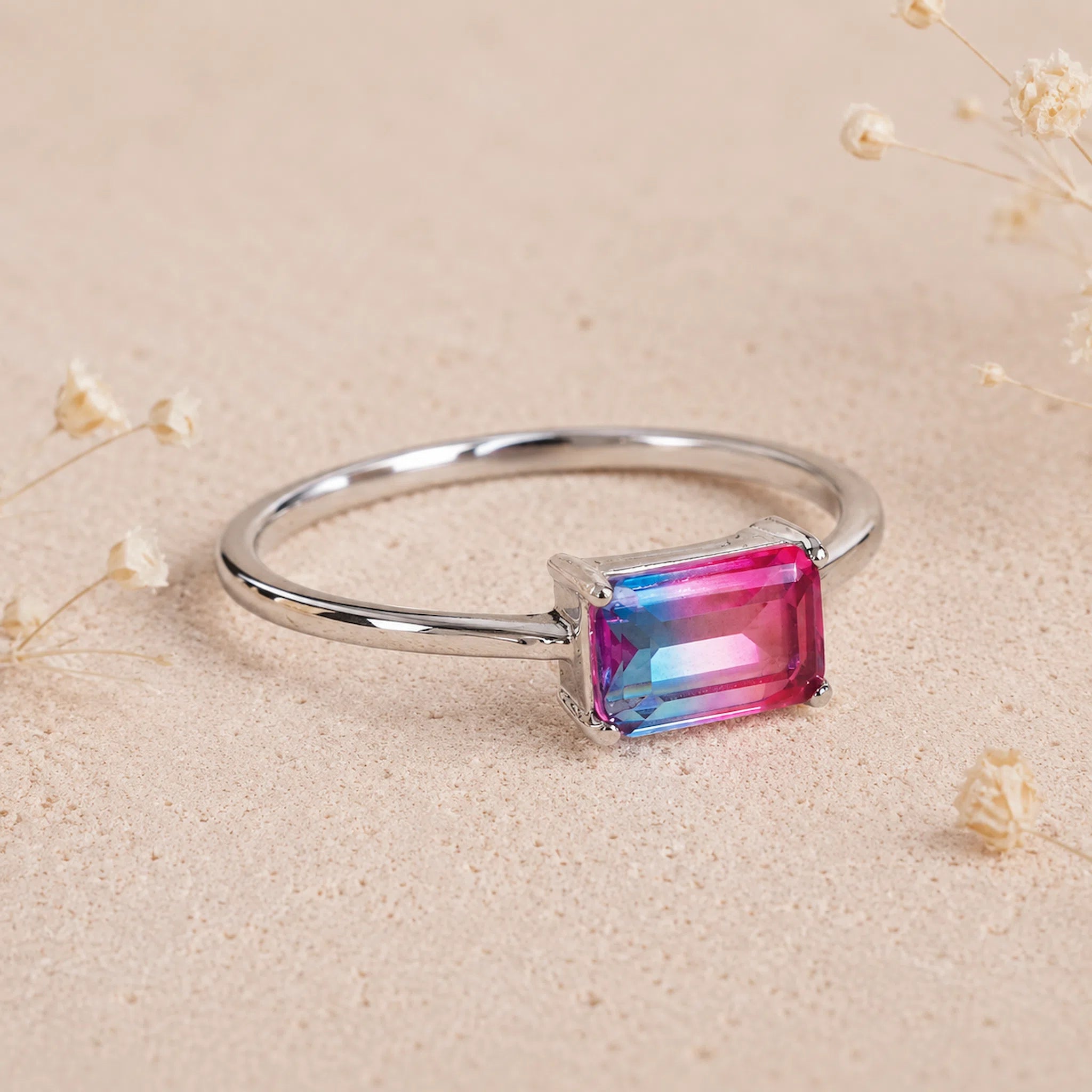 side view of Sterling Silver Ring with an Cotton Candy Tourmaline Gemstone with blue and pink colours on a light surface.