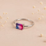 side view of a Sterling Silver Ring with an emerald cut Cotton Candy Tourmaline Gemstone with blue and pink colours on a soft light surface.