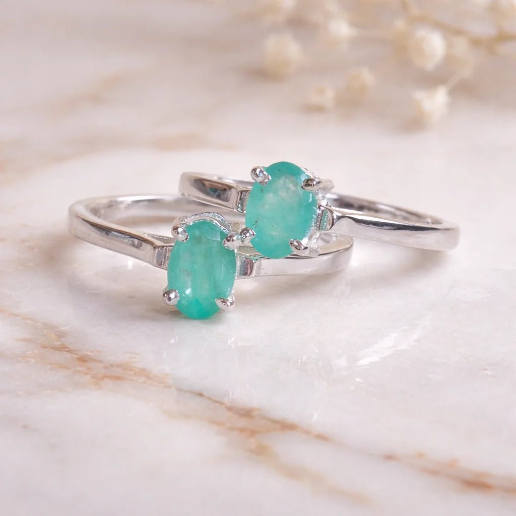 Sterling Silver rings with a oval solitaire claw set natural emerald gemstone on a light background