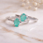 Sterling Silver rings with a oval solitaire claw set natural emerald gemstone on a light background