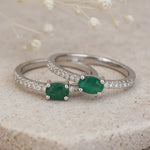 Silver emerald rings with green natural emerald gemstones on a textured surface