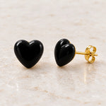 Black epoxy heart stud earrings in gold PVD stainless steel, angle view