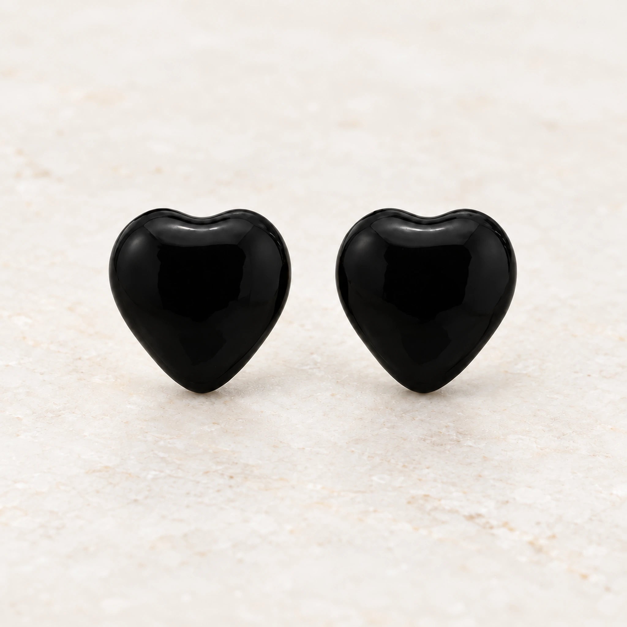 Black epoxy heart stud earrings in gold PVD stainless steel, front view
