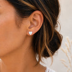White epoxy heart stud earrings in gold PVD stainless steel, worn view