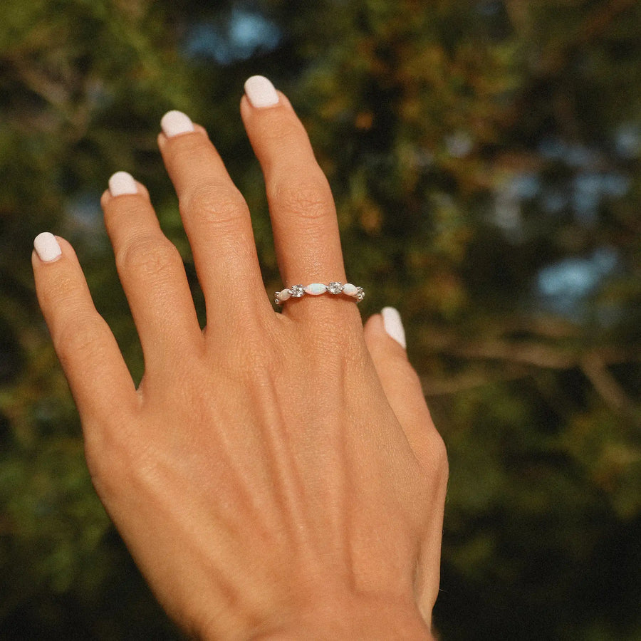woman's hand with an opal and cubic zirconia band ring