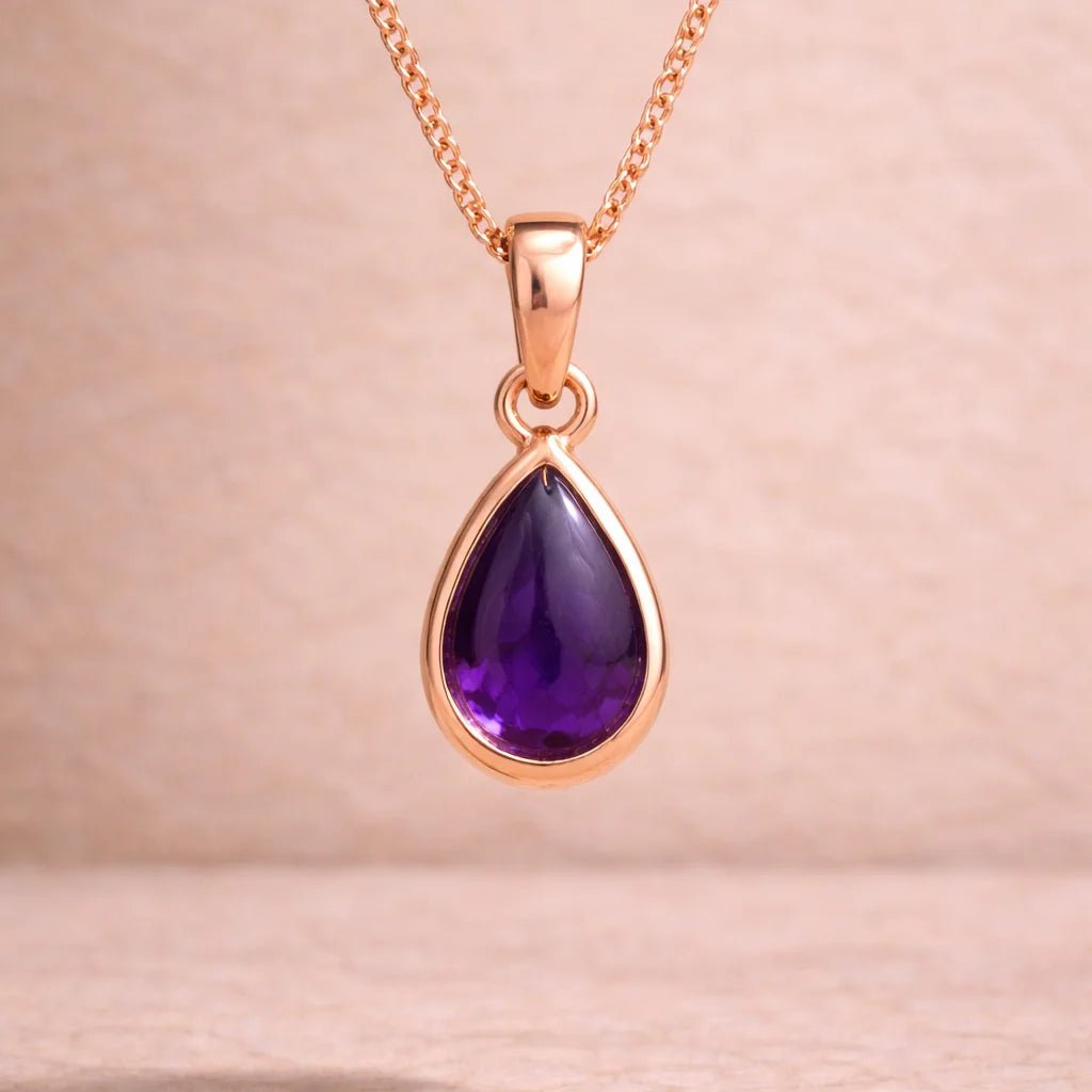 Rose gold necklace with a purple teardrop natural amethyst pendant on a beige background