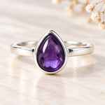 Sterling silver February natural amethyst birthstone ring on ivory stone