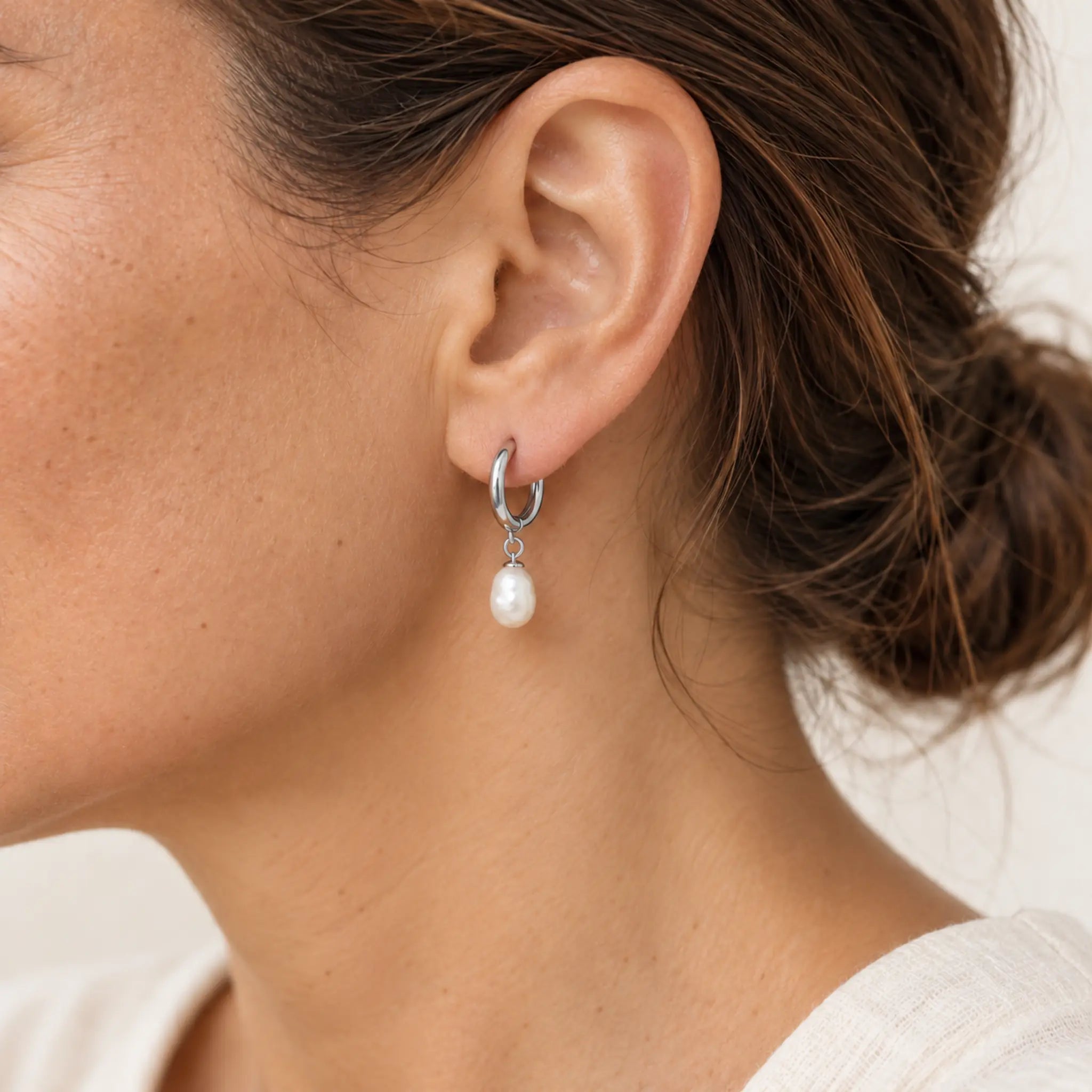 Freshwater pearl hoop earrings in silver PVD-plated stainless steel, earring worn on the ear to show its scale