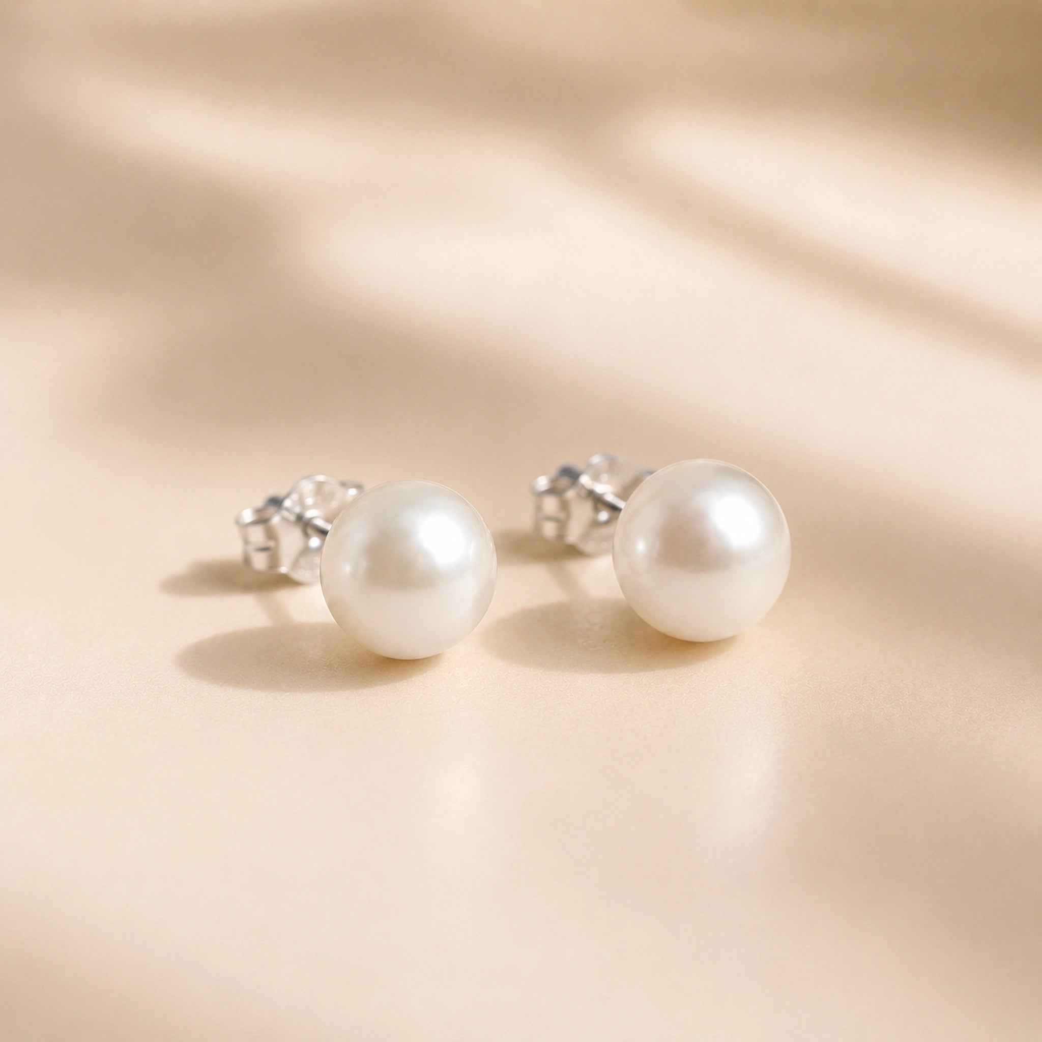 Sterling Silver Classic 7mm Natural Freshwater Pearl Stud Earrings on a light background.