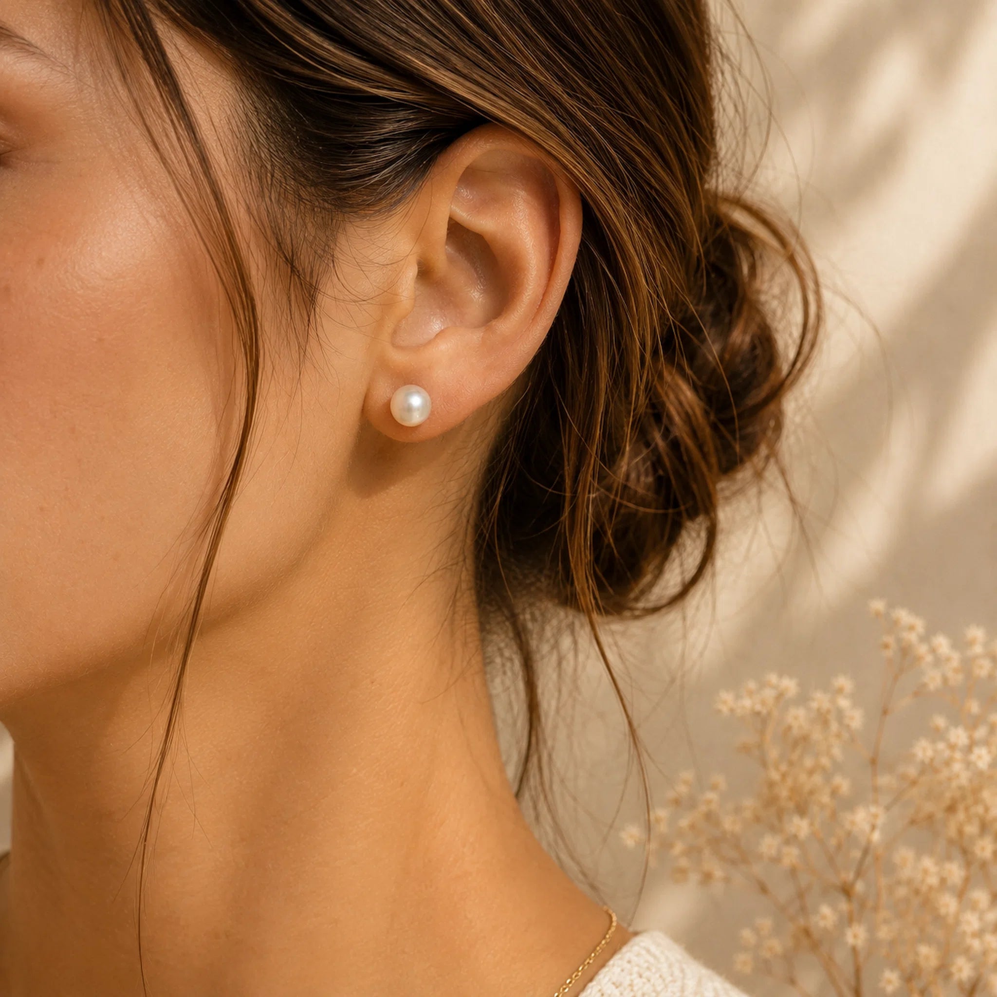 Sterling Silver Classic 7mm Natural Freshwater Pearl Stud Earrings worn on a woman with a light background.