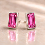 Fuchsia Austrian crystal baguette stud earrings in polished sterling silver, angled view