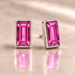 Fuchsia Austrian crystal baguette stud earrings in polished sterling silver, one front facing and one angled