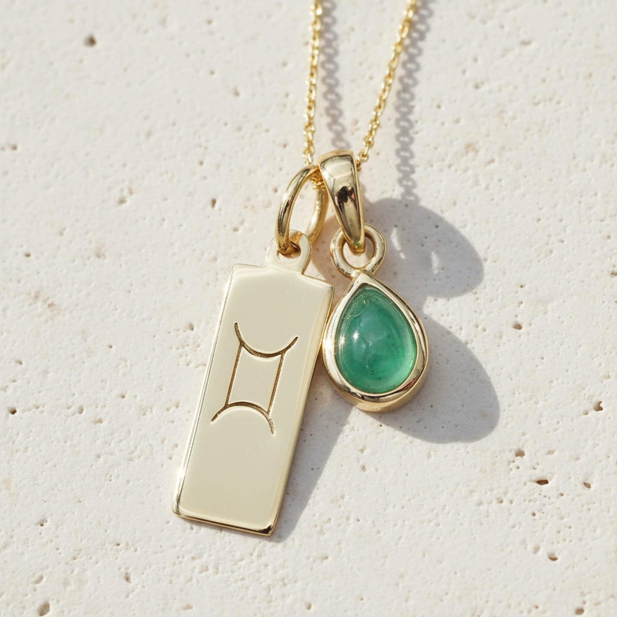 Gold May Birthstone necklace with a pear-shaped natural emerald gemstone and Gemini zodiac pendant