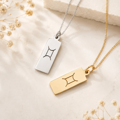 gemini zodiac line glyph pendant necklaces in sterling silver and 9k gold plated sterling silver on a light surface