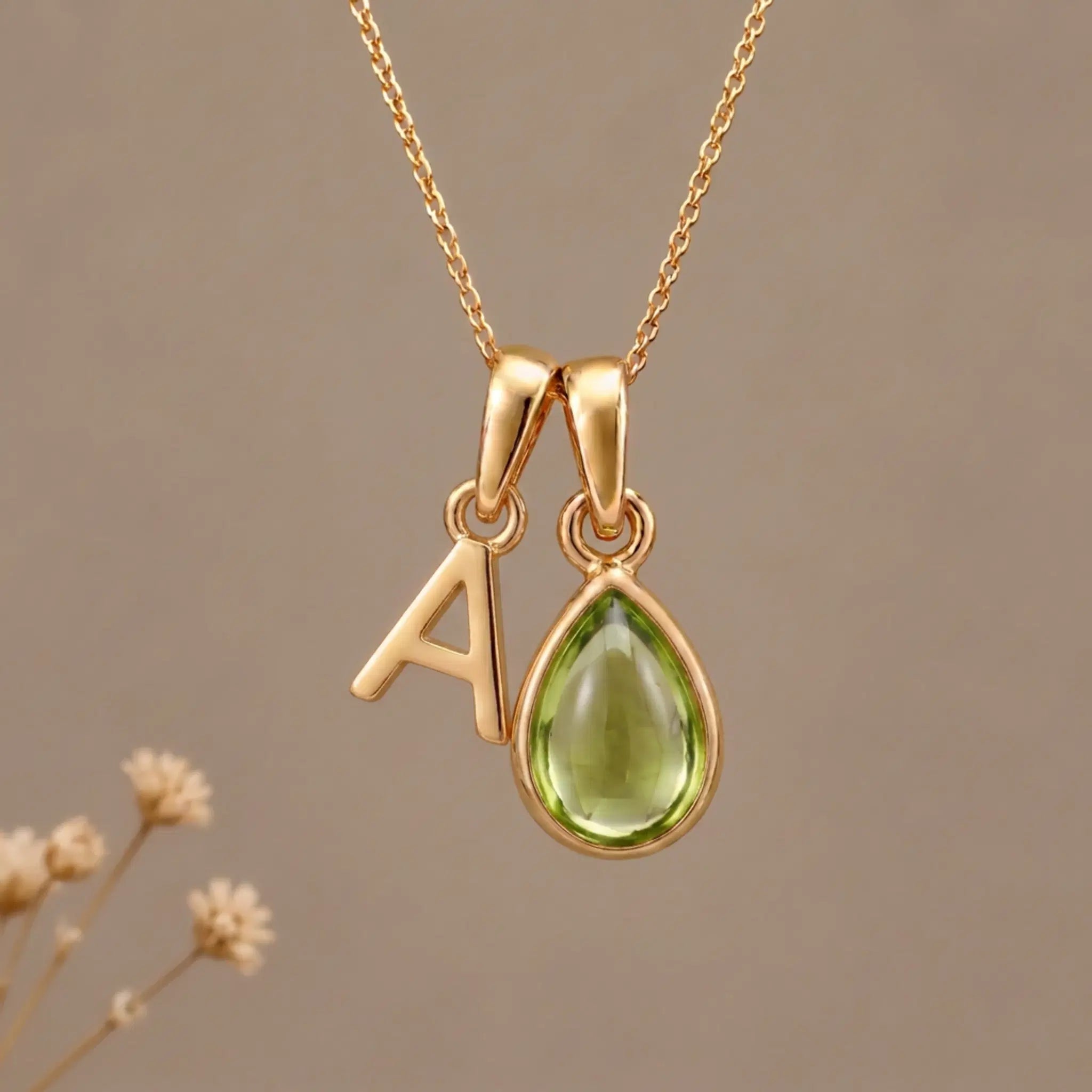 Gold Initial A Pendant and August birthstone Natural Peridot Necklace against a warm background