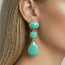 Close-up of a woman wearing turquoise earrings with a blurred background
