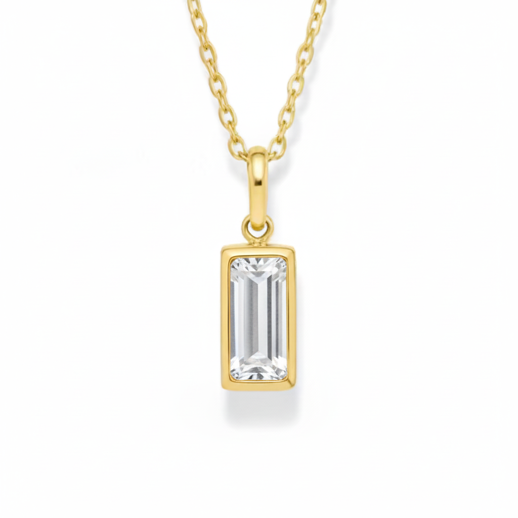 Gold pendant necklace with a rectangular clear gemstone on a white background