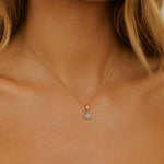 woman wearing a gold march birthstone aquamarine necklace by indie and harper australia