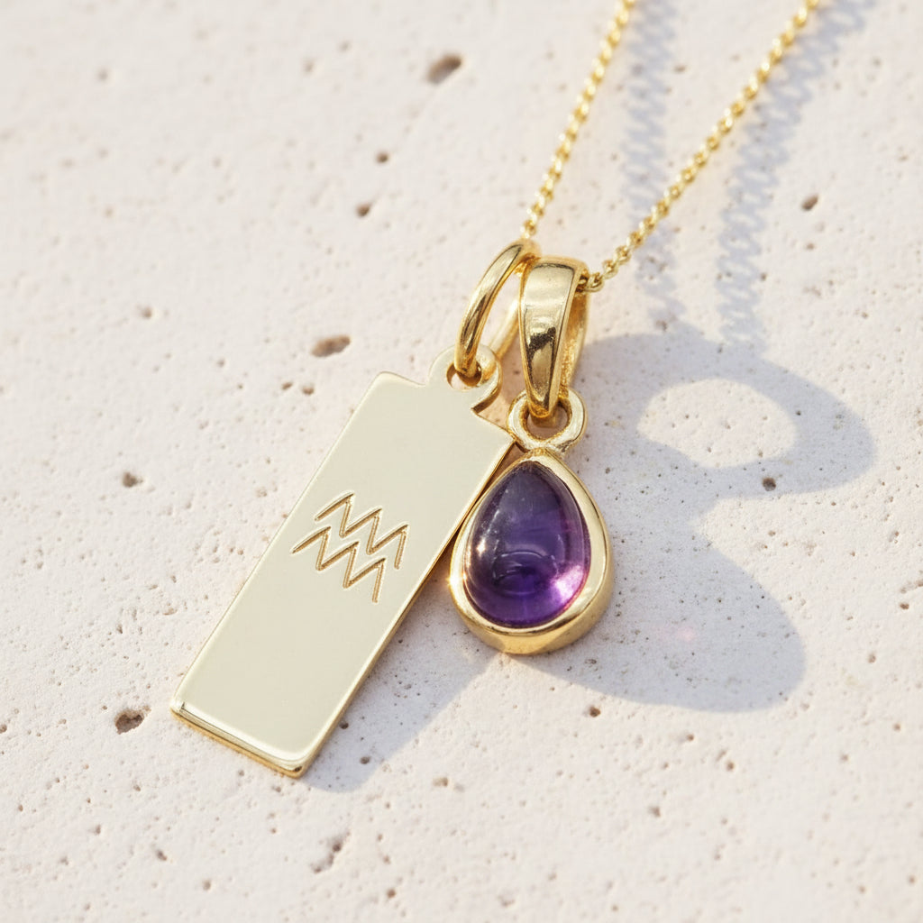 Gold Aquarius and february Birthstone amethyst Necklace on a white stone surface