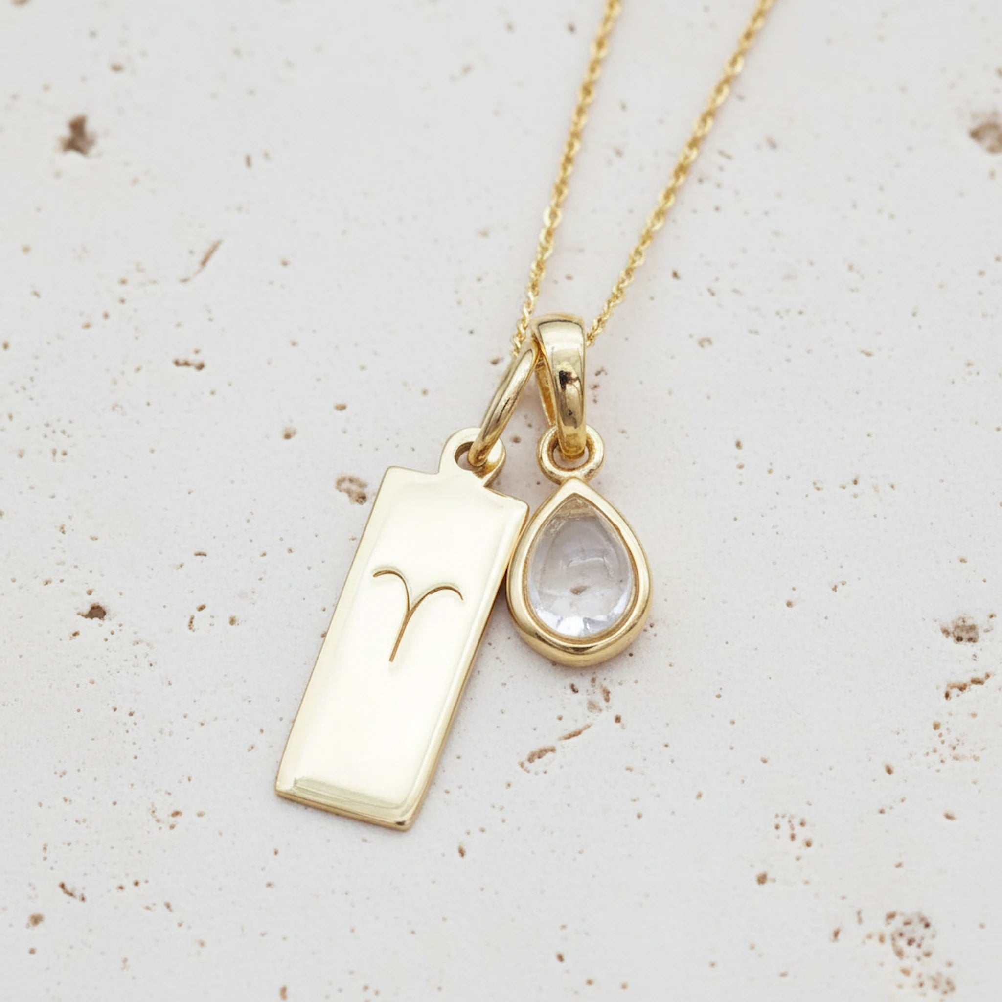 Gold April Birthstone necklace with a pear-shaped natural Herkimer Quartz pendant and a Aries zodiac pendant