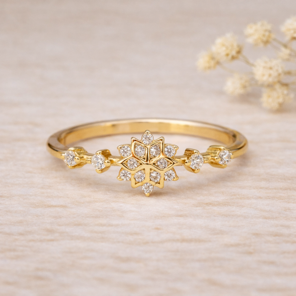 Gold ring with snowflake design and small cubic zirconias on a beige background