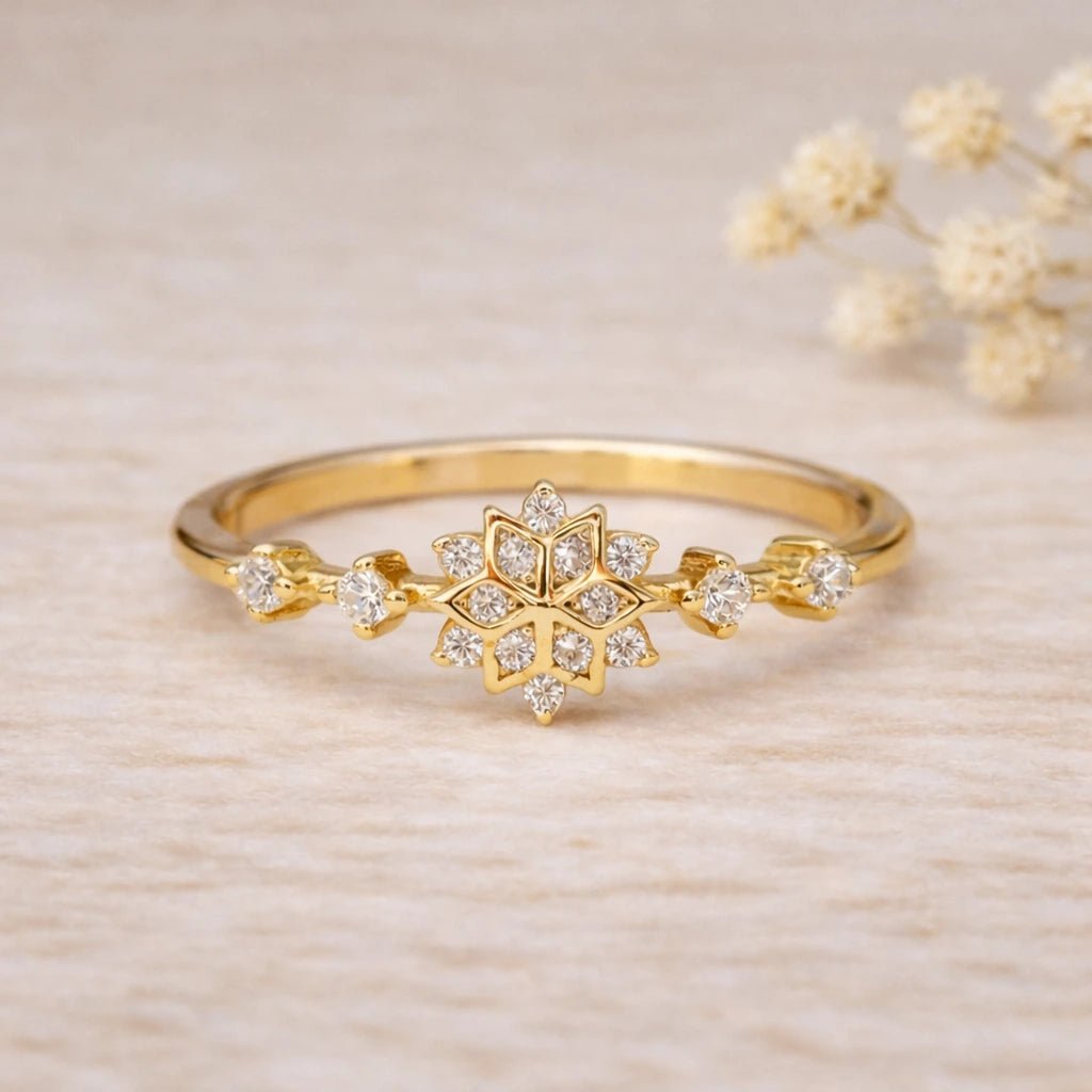 Front view of dainty gold snowflake stacking ring with twelve clear CZ stones on a slim polished band