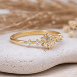 Gold ring with cubic zirconia  floral design on a stone surface