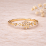 Gold ring with cubic zirconia accents on a light wooden surface