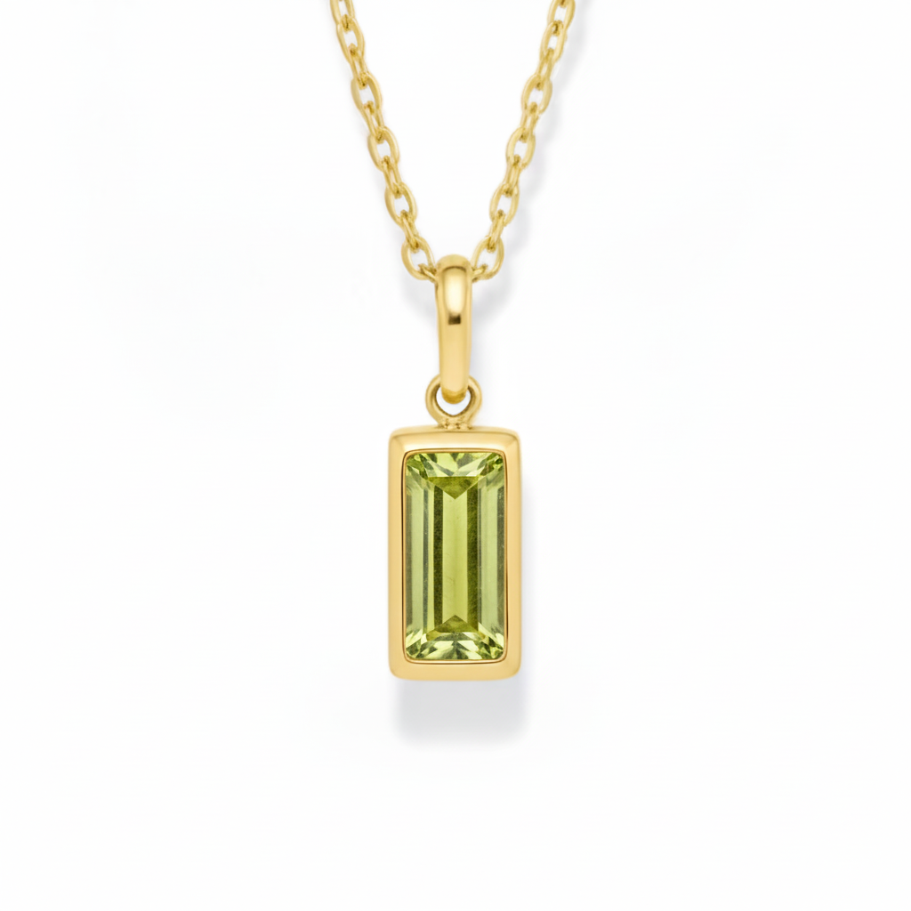Gold pendant with a green gemstone on a white background