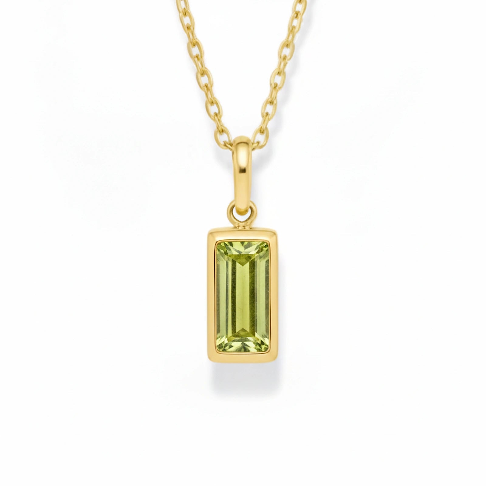 gold august birthstone necklace with light green cubic zirconia on a white background.