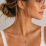 A woman wearing Gold August Birthstone Peridot Jewellery Set featuring natural peridot earrings and matching peridot necklace.