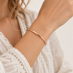 Thin 3mm minimalist classic bangle bracelet worn on the wrist with a white lace top