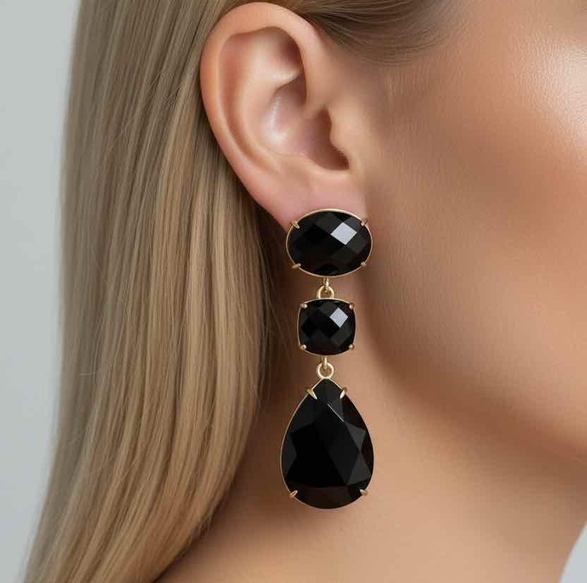 Black teardrop earrings on a model with a neutral background