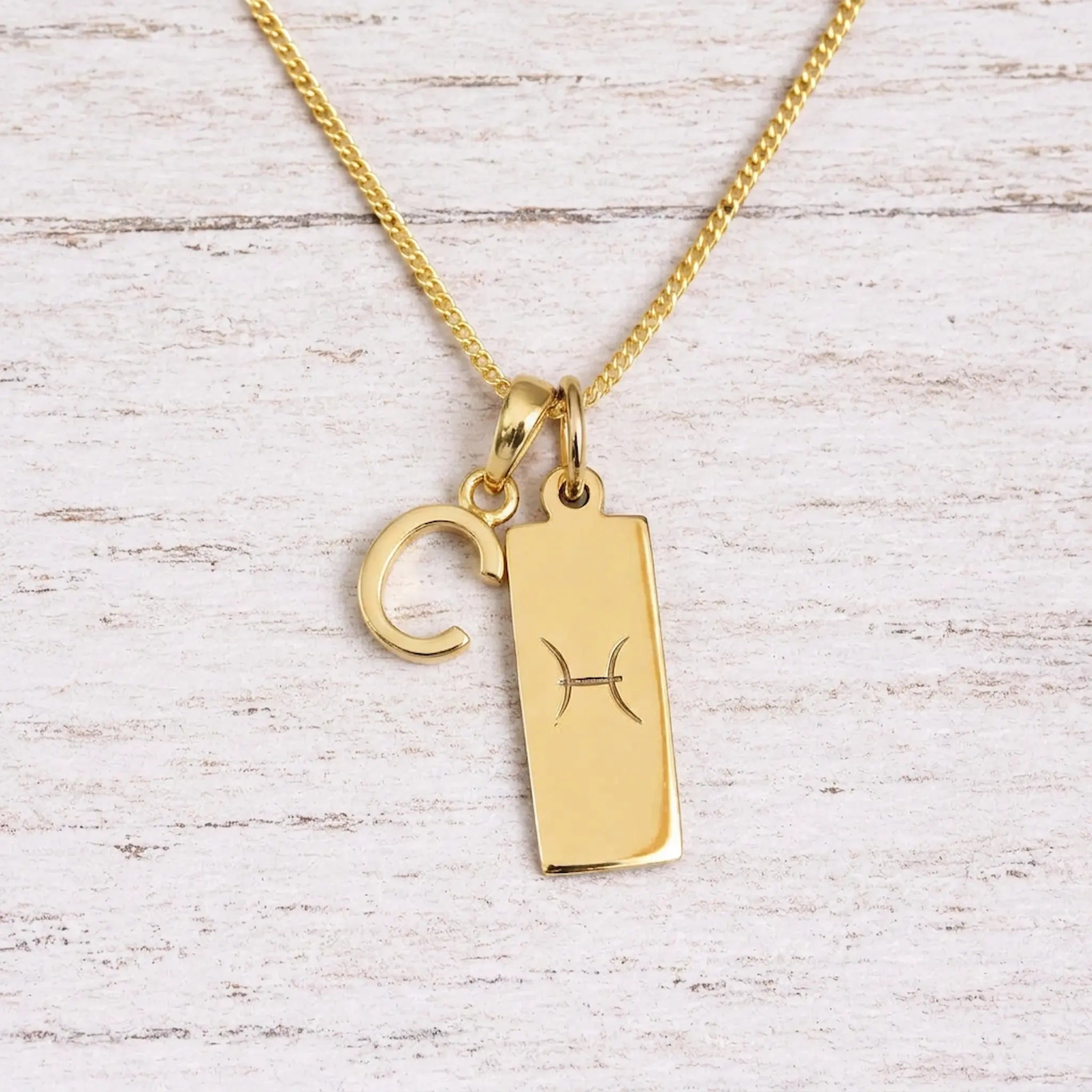 gold initial c pendant and pisces zodiac star sign pendant on a fine gold chain