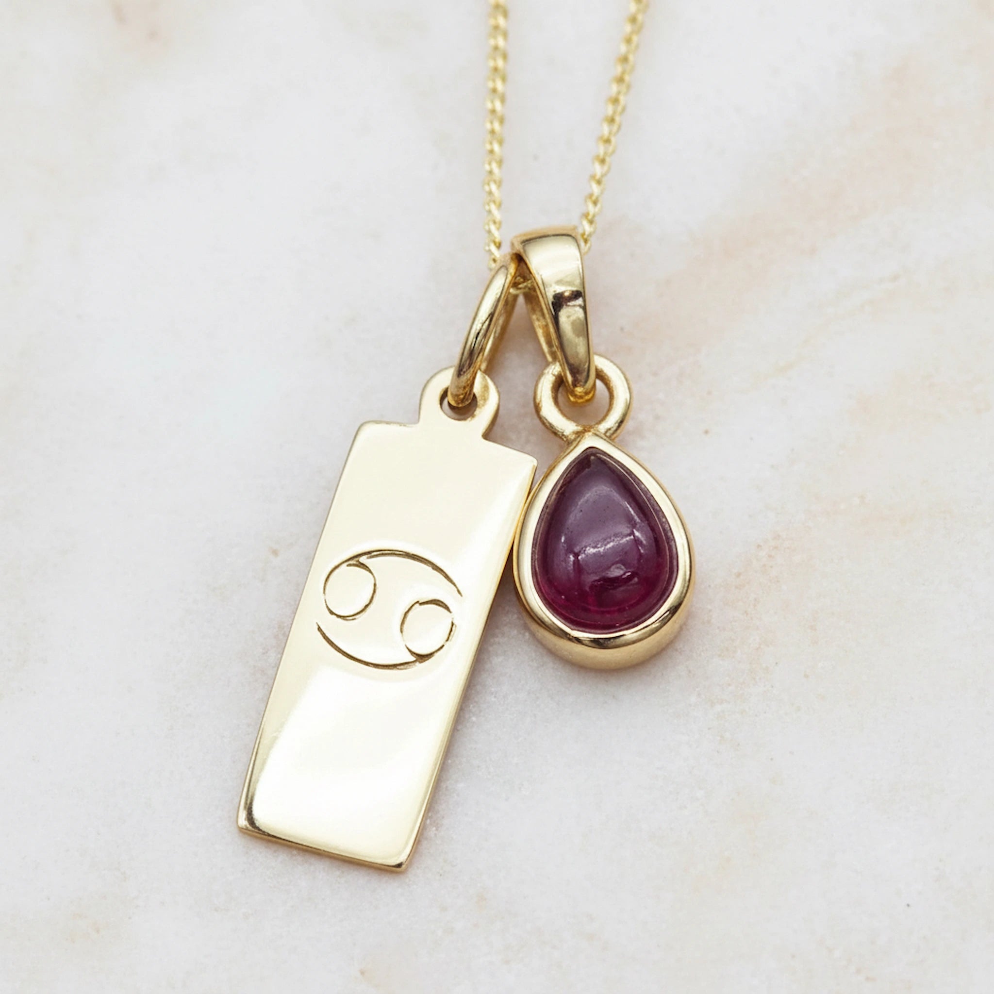 Gold July Birthstone necklace with a pear-shaped natural Ruby pendant and a Cancer zodiac pendant
