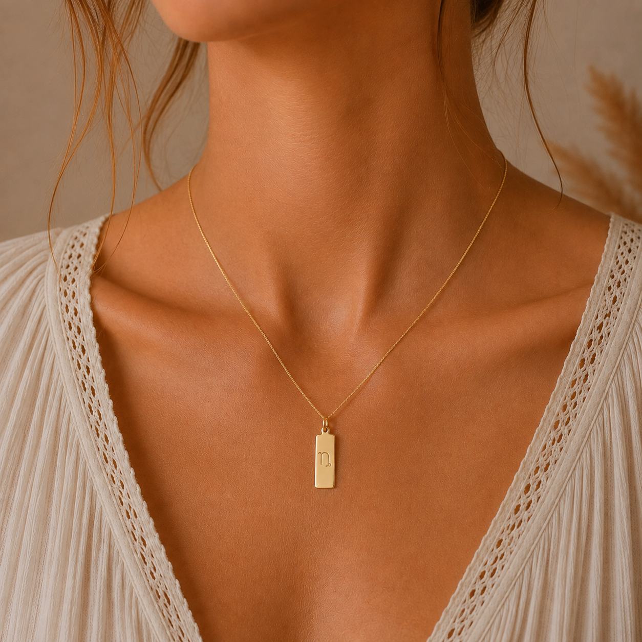 gold capricorn zodiac necklace - dainty gold fine chain necklace with a rectangle  pendant engraved with minimalist capricorn star sign line glyph being worn on model