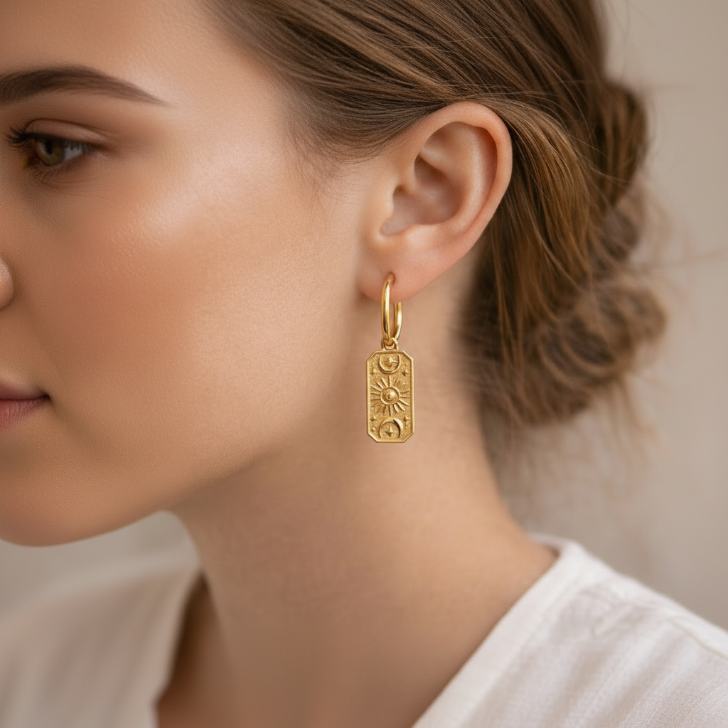 Gold earring worn by a person with a neutral background