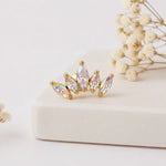 Gold earring with colorful gemstones on a light background