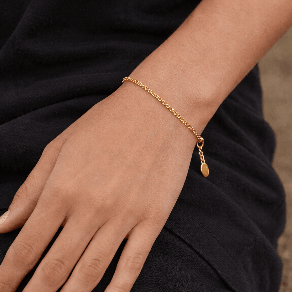 Gold bracelet on a wrist with a blurred background